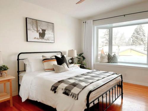 a bedroom with a large bed and a window at Modern 3BR Near Airport & DT in Calgary