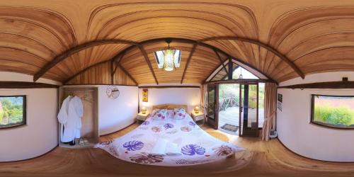 a bedroom with a bed in a room with wooden ceilings at Patate Heights in Hacienda El Carmen
