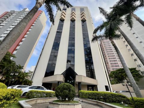 a tall building with palm trees in front of it at Hotel Bienal Ibirapuera Un409 in Sao Paulo