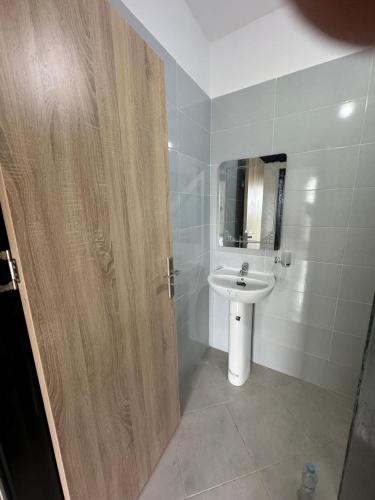 a bathroom with a sink and a wooden door at Ali Vista Vactions in Daidatz