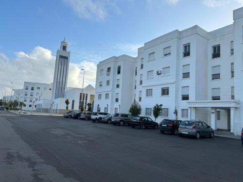 a large white building with cars parked in a parking lot at Ali Vista Vactions in Daidatz