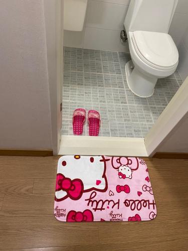 a bathroom with a hello kitty rug next to a toilet at Sweet House Incheon in Incheon