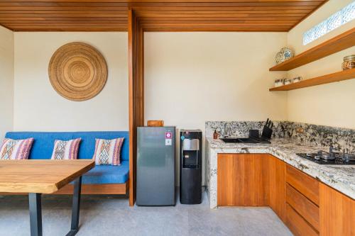a kitchen with a blue couch and a refrigerator at Blue Calm Villas Bali in Tumbak Bayuh