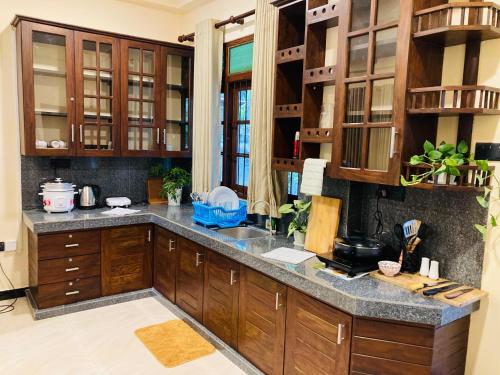a kitchen with wooden cabinets and a granite counter top at Cinnamon Edge in Mihiripenne