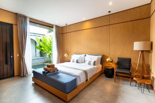 a bedroom with a bed with a teddy bear on it at Blue Calm Villas Bali in Tumbak Bayuh