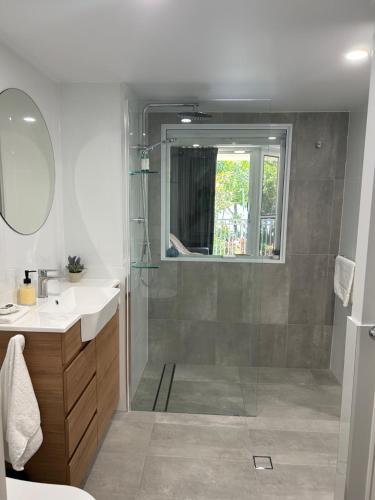 a bathroom with a shower and a sink and a mirror at Apartment 12 On Trinity Beach in Trinity Beach