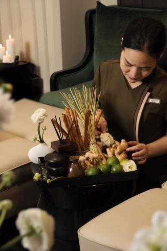a woman sitting at a table with a tray of food at Champton Hanoi Hotel in Hanoi