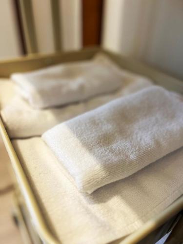 a row of white towels sitting on a bed at 清里札弦Arun別邸 in Kiyosato