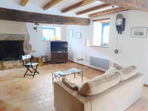 un salon avec un canapé et une cheminée dans l'établissement Maison en pierre pour 6 personnes à 400m de la plage, Secteur Logeo - FR-1-639-139, à Sarzeau