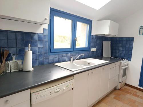 une cuisine avec un évier et une fenêtre dans l'établissement Maison en pierre pour 6 personnes à 400m de la plage, Secteur Logeo - FR-1-639-139, à Sarzeau
