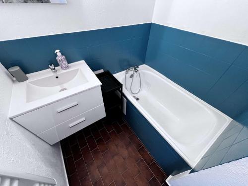 La salle de bains est pourvue d'un lavabo, d'une baignoire et d'un lavabo blanc. dans l'établissement Studio Cabine Calme, Vue Canal, Près Commerces - FR-1-702-71, au Cap d'Agde