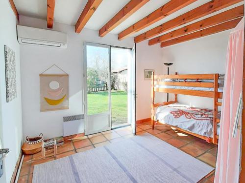 a bedroom with a bunk bed and a sliding glass door at Maison Landaise pour 12 personnes proche océan, piscine, WIFI inclus - FR-1-50-165 in Bias