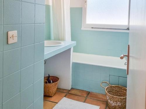 a blue bathroom with a sink and a basket at Maison Landaise pour 12 personnes proche océan, piscine, WIFI inclus - FR-1-50-165 in Bias