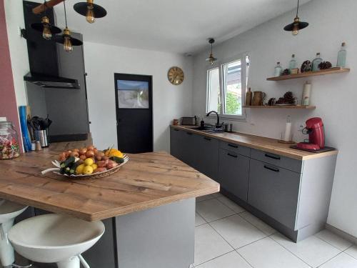 une cuisine avec un bol de fruits sur un comptoir dans l'établissement Maison à Escource avec Jardin et Accès Forêt - FR-1-50-166, à Escource