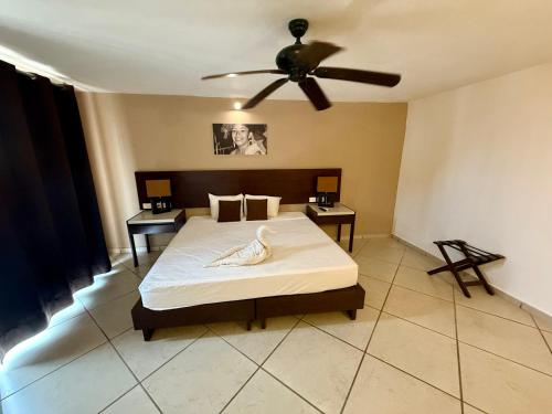 a bedroom with a bed and a ceiling fan at AMANÁA Hotel Boutique in Playa del Carmen