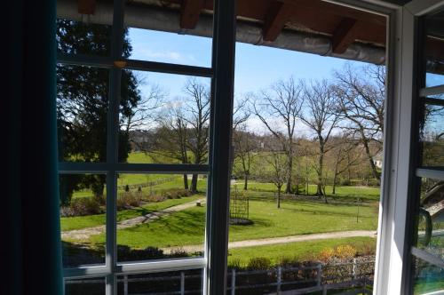 an open window with a view of a park seen through it at L'annexe in Le M&ecirc;le-sur-Sarthe