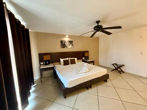 a bedroom with a bed and a ceiling fan at AMANÁA Hotel Boutique in Playa del Carmen