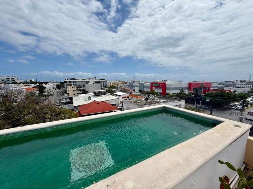 a swimming pool on a balcony with a view of a city at MULUC Playa in Playa del Carmen