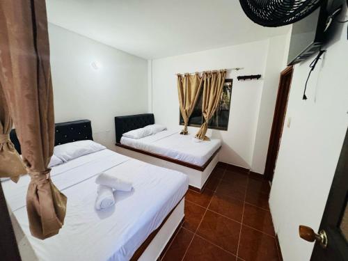 a room with two beds and a window at Hotel la Isabella SM in Villeta