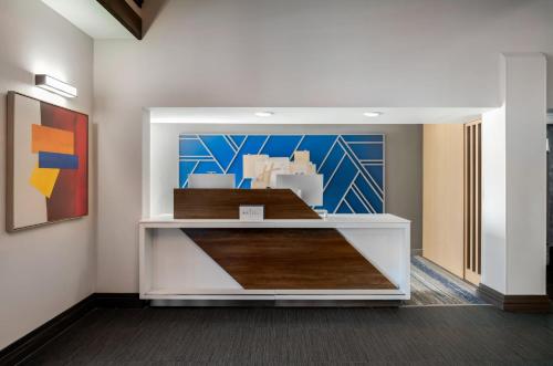 a room with a counter with a painting on the wall at Holiday Inn Express Hotel & Suites Bentonville by IHG in Bentonville