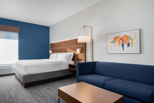 a hotel room with a bed and a couch at Holiday Inn Express Hotel & Suites Bentonville by IHG in Bentonville