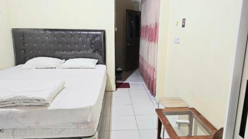 a bedroom with a bed with a metal headboard at Penginapan Bunga Sonsang Padang Syariah in Tabing