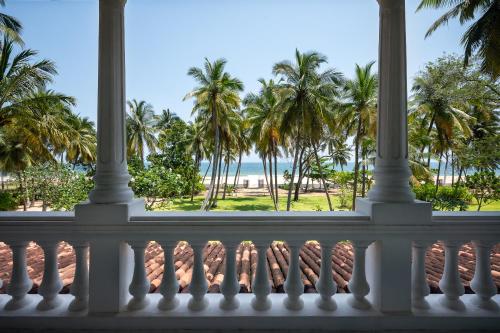 a view from the balcony of a resort with palm trees at Kalkudah Beach House in Batticaloa