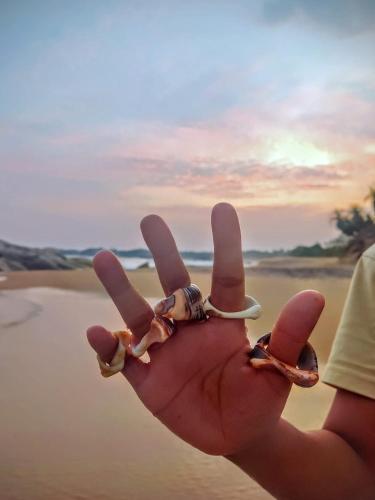 a person with their hand in the peace sign at Garnet Yala Beach in Kirinda