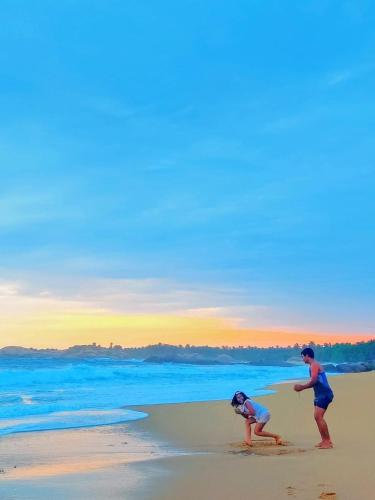 two people playing in the sand on the beach at Garnet Yala Beach in Kirinda