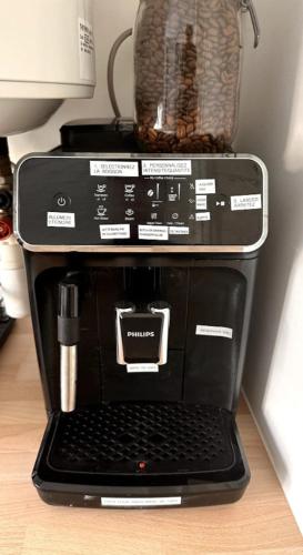 un ordinateur portable installé au-dessus d'une cafetière dans l'établissement Cosy appartement 3 chambres & parking privé, à Lyon