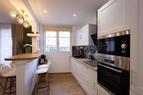 une cuisine avec des armoires blanches et un appareil noir dans l'établissement T2 center parking air conditioning Wi-Fi, à Avignon