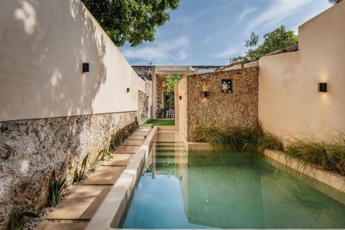 an external view of a swimming pool next to a building at Casa de la Ermita in Mérida