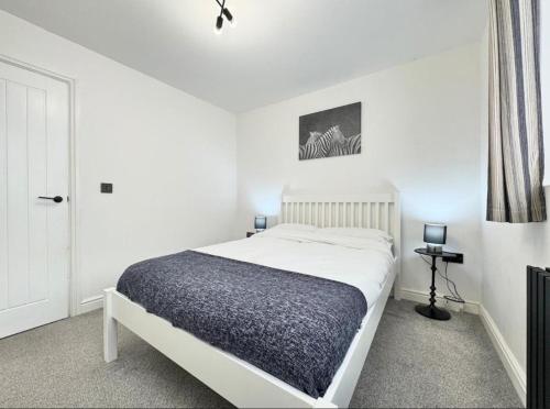 a white bedroom with a bed and a window at Doncaster 2-Beds Sleeps 4 with Parking in Doncaster