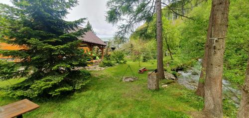 a cabin in the woods with a river and trees at Štiavnička in Mýto pod Ďumbierom