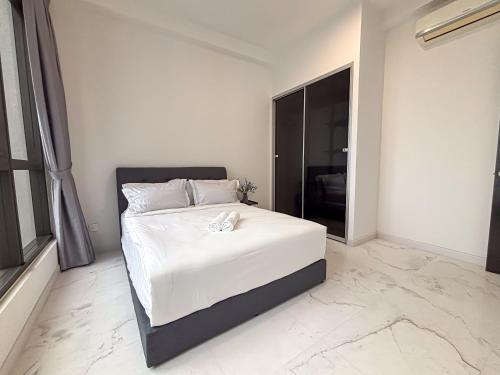 a bedroom with a large bed with a white sheets at Sky88 Seaview 4BR Indoor Pool-Mahjong-Netflix in Johor Bahru