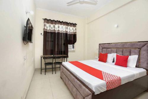 a bedroom with a large bed with red pillows at OYO 91941 Hotel golden crown in Sirhind