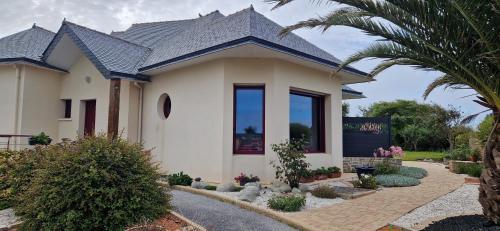 une maison blanche avec un toit noir dans l'établissement Mer D'Iroise, à Plouarzel