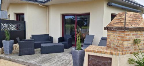 une terrasse avec des chaises et une cheminée dans l'établissement Mer D'Iroise, à Plouarzel