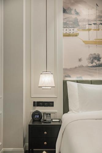 a bedroom with a bed and a clock on a night stand at CHONGQING MANQUE MANSION in Chongqing