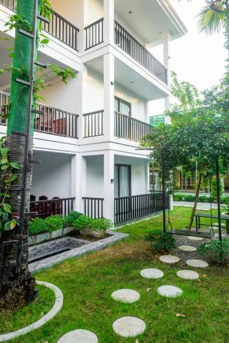 a large white building with a garden in front of it at Pich Kunthea Angkor Resort in Phumĭ Kruŏs
