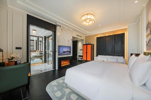 a bedroom with a large white bed and a tv at CHONGQING MANQUE MANSION in Chongqing