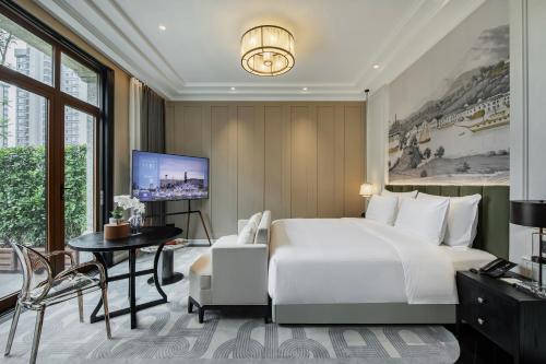 a bedroom with a bed and a desk and a tv at CHONGQING MANQUE MANSION in Chongqing