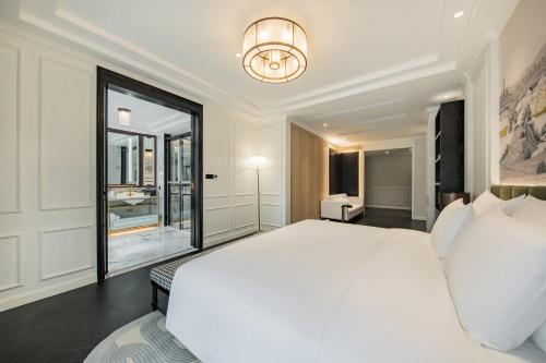 a bedroom with a white bed and a large window at CHONGQING MANQUE MANSION in Chongqing