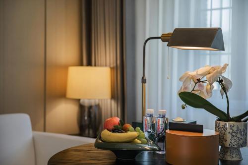 a table with a lamp and a plate of fruit on it at CHONGQING MANQUE MANSION in Chongqing