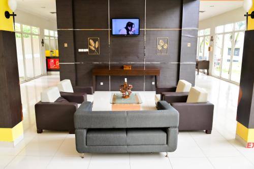 a living room with a table and couches and a tv at Hotel Bonero Residence in Bojonegoro