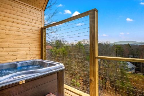 une baignoire jacuzzi dans une chambre avec fenêtre dans l'établissement The Flame Azalea - Luxury Treehouse - Hot Tub, Wi-Fi, Soaring Views, 10 Min to PF - Perfect for Couples!, à Sevierville