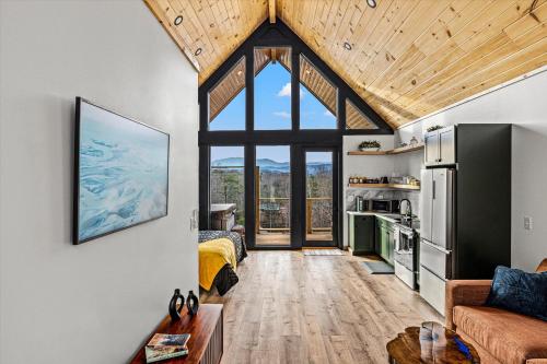 un salon avec une grande fenêtre et un canapé dans l'établissement The Flame Azalea - Luxury Treehouse - Hot Tub, Wi-Fi, Soaring Views, 10 Min to PF - Perfect for Couples!, à Sevierville