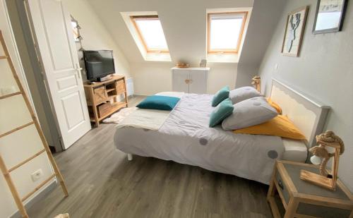 - une chambre avec un lit doté d'oreillers et une télévision dans l'établissement Ty Caïrn - Porte du Crouesty, à Arzon