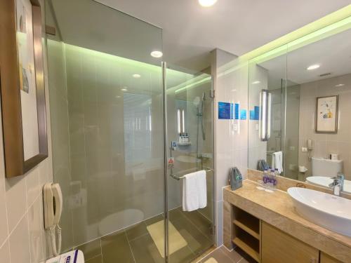a bathroom with a glass shower and a sink at Holiday Inn Express Beijing Yizhuang by IHG - Taxi 1 Hour to International Airport and 800 Meters to the Nearby Subway in Daxing