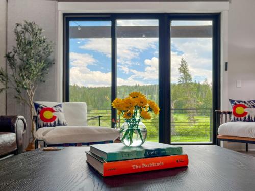 a vase of flowers sitting on a table with books at Rock n Stars Chalet townhouse in Hideaway Park